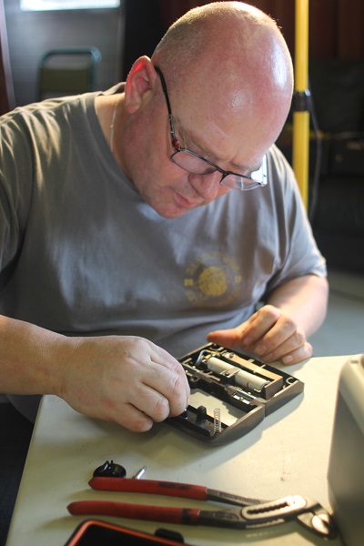Volunteer at Penrith Repair Cafe fixing a sewing machine foot pedal